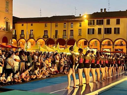 Giovani ballerine in esibizione su un palco in piazza tra il pubblico durante Imola di Mercoledì