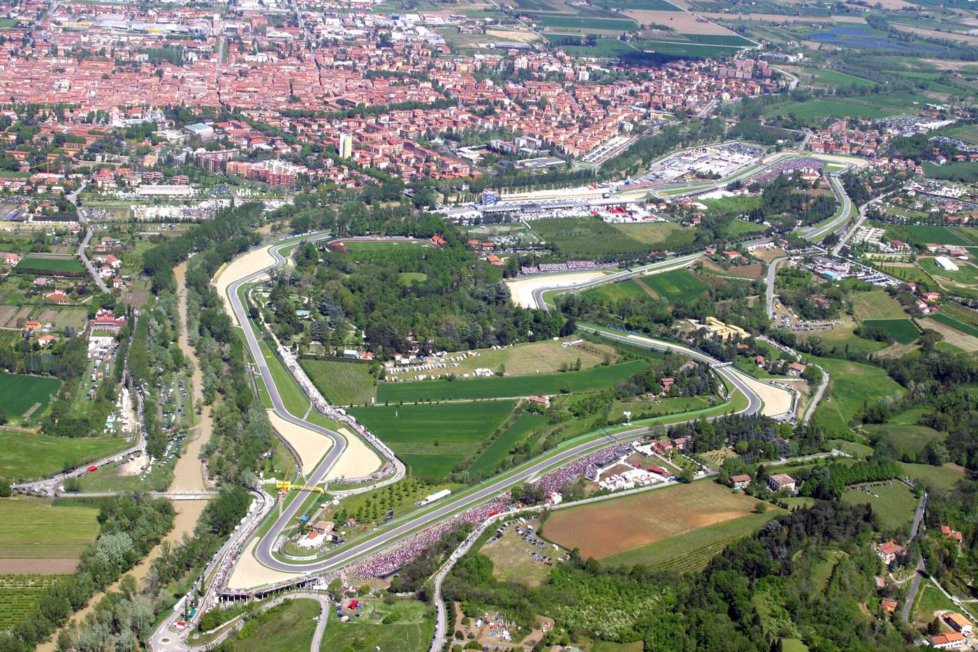Vista aerea dell'Autodromo Enzo e Dino Ferrari di Imola tra il fiume Santerno, il Parco delle Acque Minerali e la città