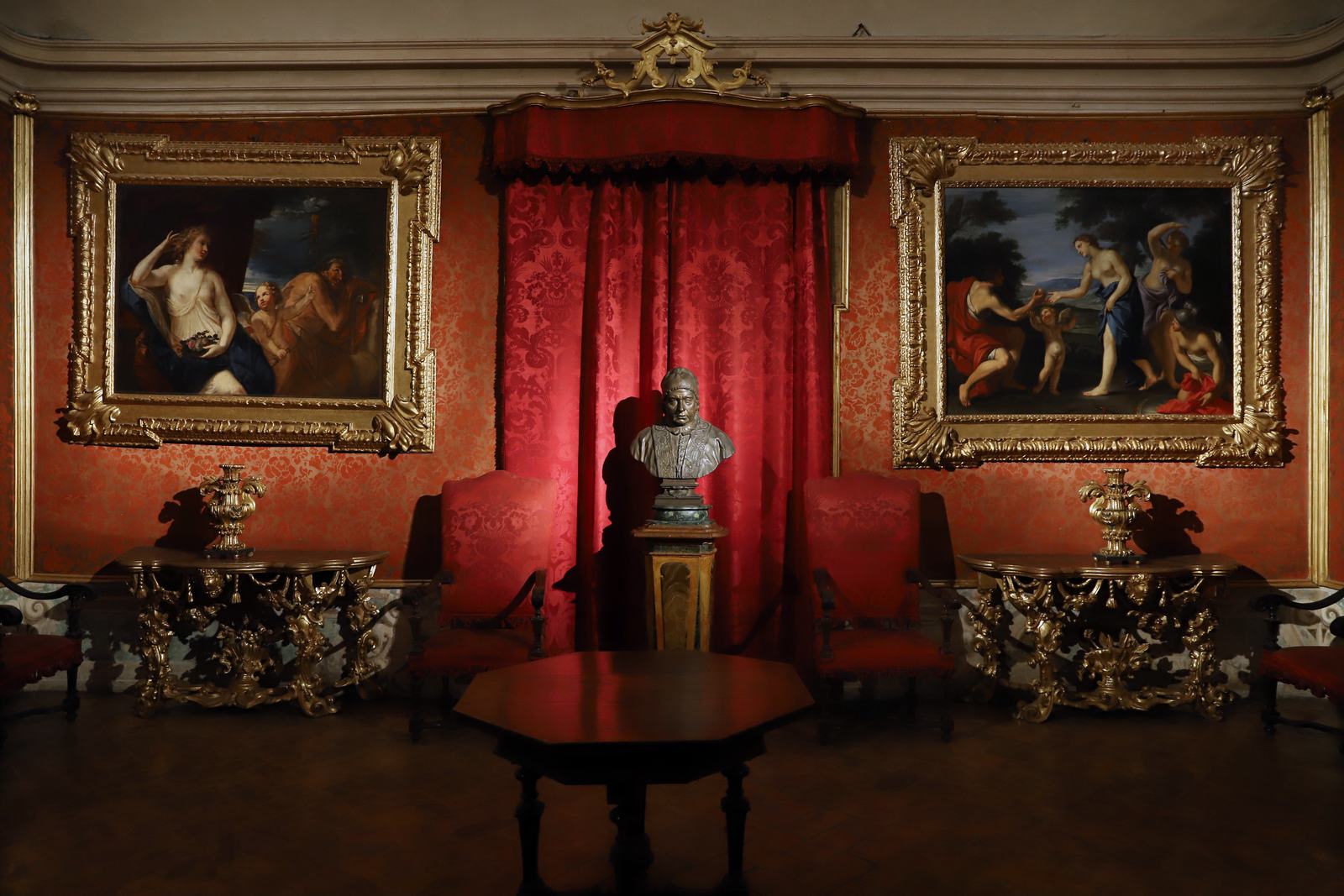 Il Salotto del Papa a Palazzo Tozzoni, con le pareti rosse, i dipinti e il busto di papa Benedetto XIV